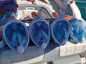 A collection of snorkel masks neatly arranged on a boat, ready for underwater adventures. Perfect for exploring vibrant marine life during your boating trip.