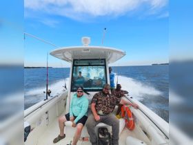 A group of friends enjoys a fishing trip on a boat, capturing the thrill of on-water activities and camaraderie. Perfect for adventure seekers looking to make lasting memories.