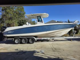 A sleek speedboat, the 320 Outrage, is docked and ready for adventure, showcasing its stylish design and robust build.