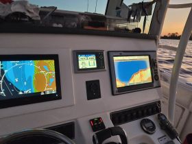 A detailed view of the helm and navigation equipment inside a boat, showcasing essential instruments for navigation and control.