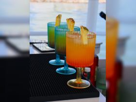 A vibrant display of colorful cocktails garnished with pineapple, perfect for enjoying on a boat. Ideal for creating a festive atmosphere during any nautical adventure.