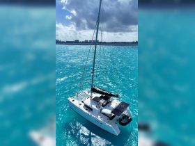 A stunning aerial view of a catamaran sailing through crystal-clear turquoise waters, perfect for showcasing luxury boating experiences.