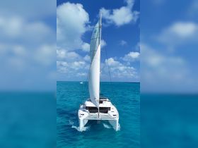 A stunning aerial view of a catamaran sailing through crystal-clear turquoise waters, showcasing the beauty of nautical adventures.