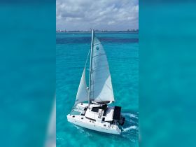 A stunning aerial view of a catamaran sailing through crystal-clear turquoise waters, perfect for exploring beautiful coastal destinations.
