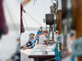 A cheerful group enjoys a sunny day sailing, capturing the essence of camaraderie and adventure on the water.