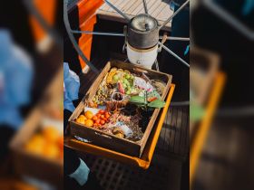 A beautifully arranged charcuterie board featuring a variety of fruits, meats, and snacks, perfect for enjoying on a boat trip.