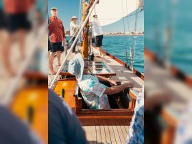 A group of people actively sailing on a boat, showcasing the camaraderie and excitement of a day on the water.