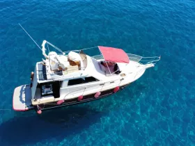 Aerial view of a beautiful yacht anchored in crystal-clear waters, showcasing its elegant design and inviting deck space.