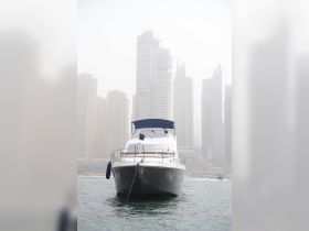 A sleek yacht is docked in front of a stunning skyline, showcasing the perfect blend of luxury and urban scenery.