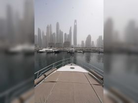 A stunning view from the bow of a yacht docked in a bustling marina, showcasing the impressive skyline of a modern city.