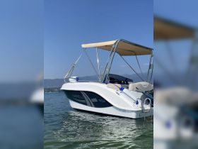 A sleek Marinello boat glides through calm waters, showcasing its elegant design and perfect for leisurely outings on the water.