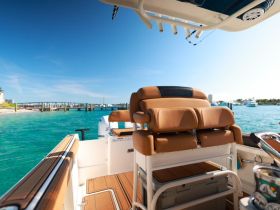 A well-designed helm area of a boat featuring comfortable seating and a clear view of the turquoise waters, perfect for navigating scenic routes.