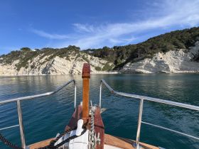 A stunning view from the front of a boat, showcasing the serene waters and rocky coastline, perfect for exploring beautiful destinations.