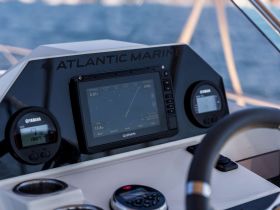 A close-up view of the helm and console of a boat, featuring advanced navigation equipment and gauges, ideal for marine enthusiasts and boaters.