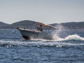 A speedboat cuts through the sparkling waters, showcasing an exhilarating day on the water — perfect for adventure seekers and boating enthusiasts.