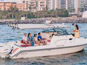 A joyful group enjoys a scenic boat ride, with a couple sharing a romantic moment on deck — perfect for celebrations and memorable outings on the water.