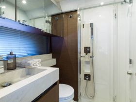 A modern boat bathroom featuring a sleek design with a shower, sink, and storage, perfect for onboard comfort and convenience.