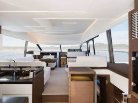 A sleek and modern interior of a yacht showcasing spacious seating and a well-equipped helm, perfect for luxurious cruising experiences.