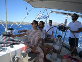 A group enjoys a sailing experience on a yacht, with beautiful blue waters in the background — perfect for memorable adventures on the sea.