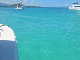 A stunning view of turquoise waters with boats in the distance, capturing the essence of a perfect day on the water.