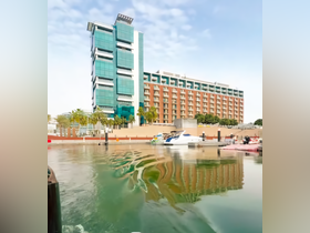A view of a marina with boats and a hotel in the background, showcasing a vibrant waterfront scene.