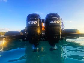 A striking view of a boat's powerful outboard motors against a clear blue sky, showcasing the vessel's sleek design and performance capabilities.