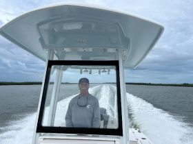 A captain navigates a boat through calm waters, showcasing the thrill of boating adventures on the open sea.
