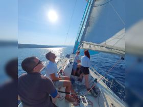A lively group enjoys a sunny sailing adventure on the open ocean, capturing the essence of fun and camaraderie on the water.