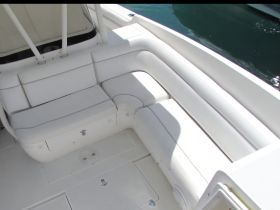 Interior view of a boat's seating area, showcasing comfortable white cushions and a clean, spacious layout — perfect for relaxing on the water.