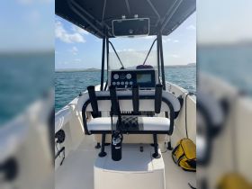 Interior view of a boat's helm and seating area, showcasing the console and storage options — ideal for fishing or leisure outings.