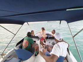 A lively group enjoys a boat ride, engaging in conversation and fun on the water — perfect for memorable outings with friends.