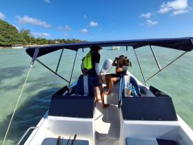 Two individuals aboard a boat enjoy their time on the water, showcasing a relaxed atmosphere perfect for adventure or leisure outings.
