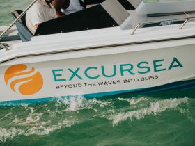 A close-up of the ExcursEA boat in action, showcasing its vibrant branding and the excitement of a water adventure.