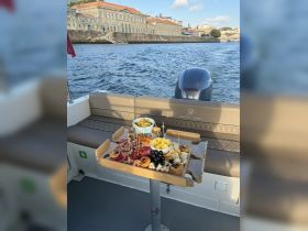 A beautifully arranged charcuterie board featuring a variety of snacks and fruits, perfect for enjoying on a boat trip.