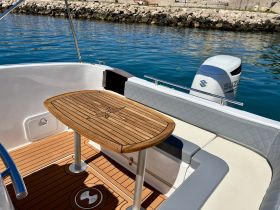 A well-appointed interior view of a boat featuring a stylish wooden table and comfortable seating, perfect for relaxing while on the water.
