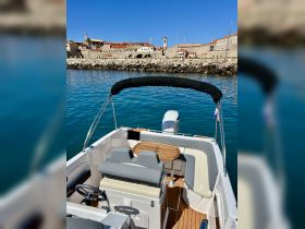 A well-appointed interior of a boat featuring comfortable seating and a helm, perfect for enjoying a day on the water.