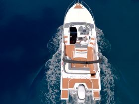 Aerial view of a sleek speedboat in motion, showcasing its elegant design and spacious deck — perfect for thrilling water adventures.