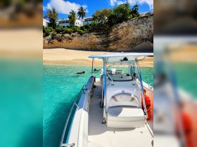 Guests enjoy snorkeling in the clear waters near a beautiful beach, with stunning cliffs and tropical vegetation in the background — a perfect day for aquatic adventures.