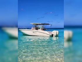A sleek speedboat named 'Timeless 1' docked in crystal-clear waters, perfect for a day of adventure on the sea.