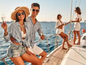 A joyful group enjoys a sunny day on a yacht, celebrating with cocktails and laughter — perfect for memorable outings and special occasions on the water.