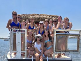 A lively group of friends celebrates together on a boat, perfect for bachelorette parties or summer gatherings on the water.