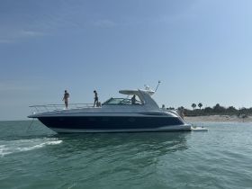 A lively scene aboard a boat with guests enjoying the sun and water, showcasing a perfect day at the beach.