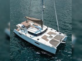 A stunning aerial view of a sleek catamaran sailing through clear waters, showcasing its spacious deck and luxurious design, perfect for unforgettable sailing adventures.