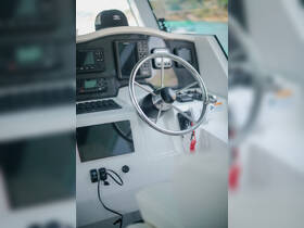 A detailed view of the helm and console inside a boat, showcasing the steering wheel and various controls, ideal for navigation and boating enthusiasts.