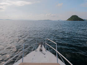 A stunning view from the front of a boat cruising through calm waters, with lush islands in the distance — perfect for exploring scenic destinations.
