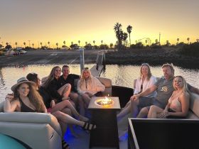 A lively group of friends enjoys a sunset gathering on a pontoon boat, creating unforgettable memories against a picturesque backdrop.