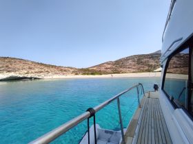 A stunning view from a boat showcasing a serene beach and clear turquoise waters, perfect for a day of exploration and relaxation.