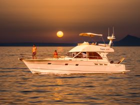 A couple enjoys a sunset cruise on a yacht, capturing the essence of relaxation and adventure on the water.