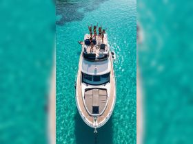 A lively group of friends celebrates on the deck of a yacht, enjoying the clear turquoise waters — perfect for summer adventures and unforgettable memories.