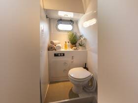 A well-appointed boat bathroom featuring towels, toiletries, and a touch of greenery, perfect for comfort on the water.